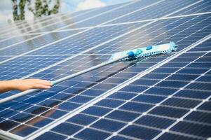 young worker cleaning solar panels. photo