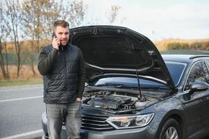 The car broke down, smokes from under the hood, the driver shocked photo