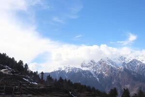 Snow on the Mountains Peak and Blue Sky and tree in India photo