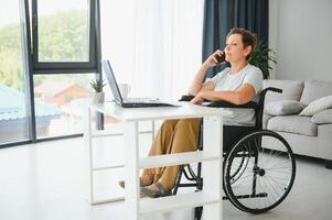 Woman who uses wheelchair working on computer photo