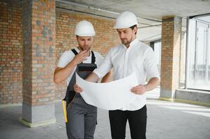 Male Architect Giving Instructions To His Foreman At Construction Site. photo