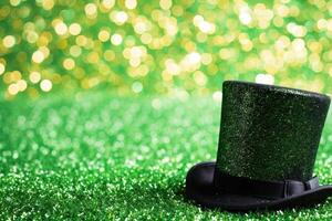 AI generated Green hat with shamrock and clover leaves on green grass background with copy space for text. photo
