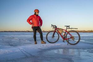 mayor masculino ciclista con su grava bicicleta en un congelado lago en Colorado - niño lago estado parque foto