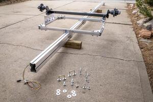 assembling a light and long aluminum kayak or canoe trailer in a driveway photo