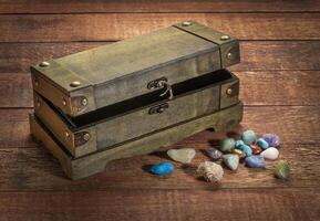 retro decorative box or treasure chest on wooden rustic table with gemstones photo