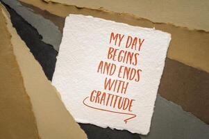 My day begins and ends with gratitude - positive affirmation words, inspirational handwriting on art paper photo