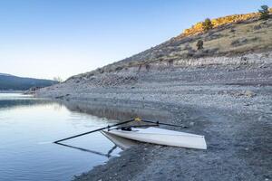 Coastal rowing shell on a shore of Carter Lake in northern Colorado at dusk in winter scenery photo