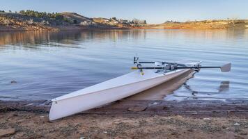 Coastal rowing shell on a shore of Horsetooth Reservoir in fall or winter scenery with a low water level. photo