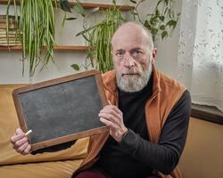 senior man with blank slate blackboard photo