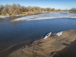 decked expedition canoe on a sandbar with ice floe - South Platte River in eastern Colorado photo