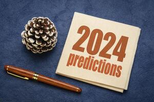 2024 predictions - word abstract on a napkin with a decorative frosty pine cone, business and financial trends and expectations in New Year photo