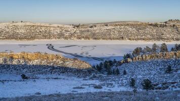 winter scenery in foothills of Rocky Mountains in northern Colorado with frozen Horsetooth Reservoir photo