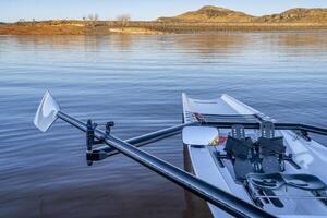 Coastal rowing shell on a shore of Horsetooth Reservoir in fall or winter scenery with a low water level. photo