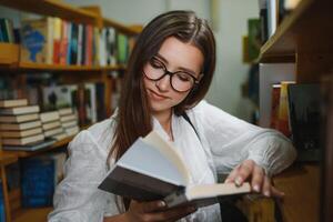 Portrait of a student girl studying at library photo