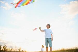 Boy is running with a kite during the day in the field photo