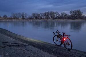 gravel bike on a shore of a frozen lake, winter dusk in northern Colorado photo