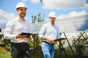 The solar farm solar panel with two engineers walk to check the operation of the system, Alternative energy to conserve the world's energy, Photovoltaic module idea for clean energy production photo