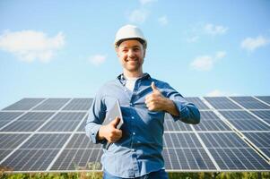 Young architect standing by solar panels photo
