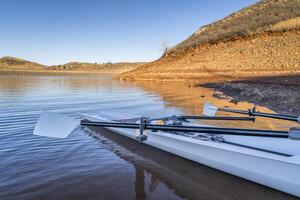 Coastal rowing shell on a shore of Horsetooth Reservoir in fall or winter scenery with a low water level. photo