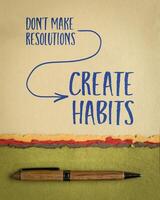 don't make resolutions, create habits -  inspirational advice or reminder on art paper, New Year resolutions, setting goals and personal development concept photo