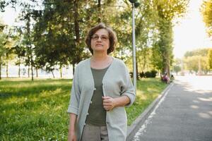 retrato de un contento mayor mujer en verano parque foto