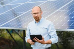 The portrait of a proud engineer smiles satisfied with his successful work. Concept renewable energy, technology, electricity, service, green power photo