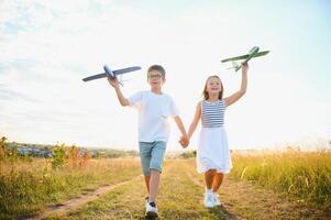 niños jugar juguete avión. concepto de contento infancia. niños sueño de volador y convirtiéndose un piloto. foto
