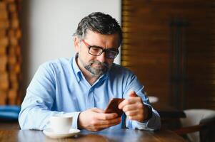 man in casual form using mobile phone at the cafe photo