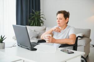 Woman who uses wheelchair working on computer photo