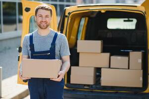 delivery service employee. Portrait of man working in delivery service. Portrait of courier with box. Courier next to minivan. Delivery service career. photo