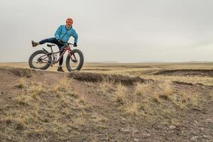 senior male cyclist with a fat mountain bike photo