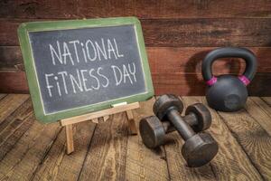 National Fitness Day is celebrated on the first Saturday of May in US, white chalk text on blackboard with dumbbells and kettlebell photo