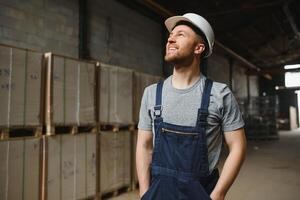 retrato de contento masculino trabajador en almacén en pie Entre estantes. foto