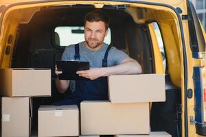 Delivery men unloading moving boxes from car photo