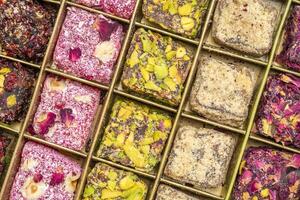 assortment of traditional Turkish delight, lokum, in a tin box against handmade paper with a copy space, soft, juicy, and chewy dessert from the middle east photo