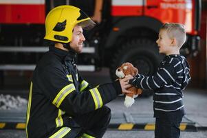 Firefighter holding child boy to save him in fire and smoke,Firemen rescue the boys from fire photo