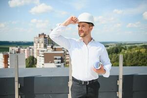 Close up engineers working on a building site holding a blueprints.Engineering and architecture concept photo