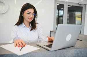 simpático joven mujer detrás el recepción escritorio administrador foto