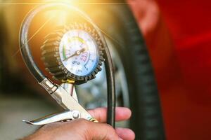 Servicio mantenimiento coche inspección medida cantidad inflado caucho llantas coche de cerca mano participación máquina inflado presión calibre coche neumático presión medición automotor automóvil cheque coche viaje foto