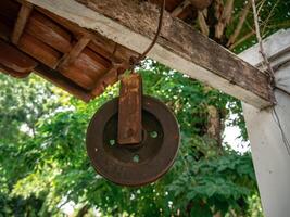 An old rusty pulley used to draw water from a medieval well in Java photo