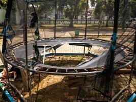 a black trampoline that was damaged, broken in the middle photo