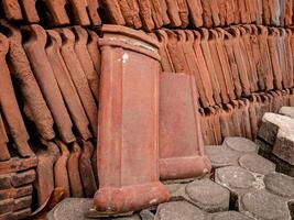 piles of roof tiles made of clay are stored outdoors photo