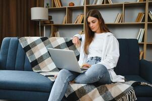 Full length portrait of cheerful charming person sit hold netbook browsing have good mood working home indoors photo