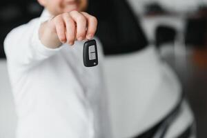 Happy man showing the key of his new car. photo