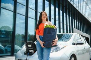 mujer es cargando alquiler eléctrico coche foto