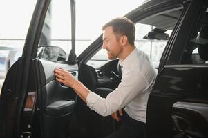 hombre en un coche concesión compra un coche foto