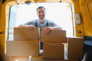 Delivery men unloading moving boxes from car photo