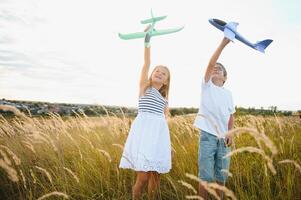 niños jugar juguete avión. concepto de contento infancia. niños sueño de volador y convirtiéndose un piloto. foto