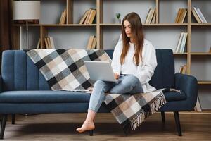 Full length portrait of cheerful charming person sit hold netbook browsing have good mood working home indoors photo