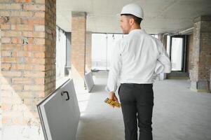 cerca arriba ingenieros trabajando en un edificio sitio participación un planos.ingenieria y arquitectura concepto foto